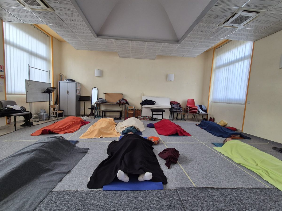 Élèves enveloppés dans leur couverture pour la relaxation finale d’un cours de yoga